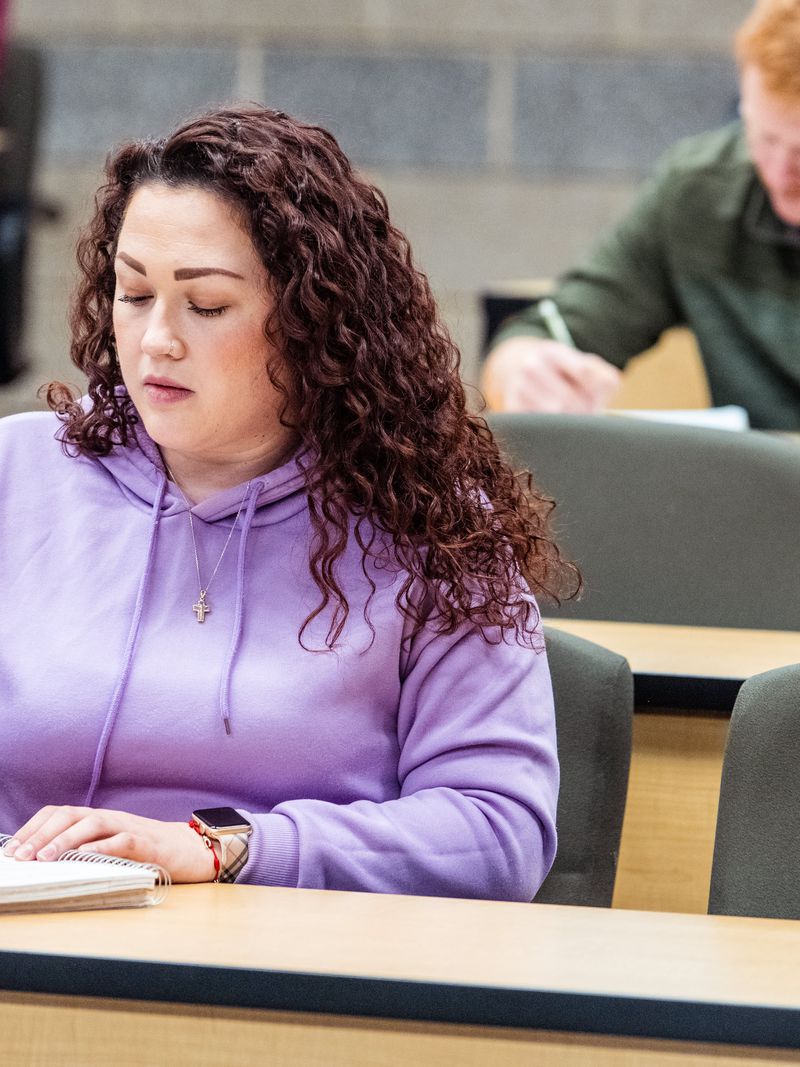 Student taking notes during a general education class