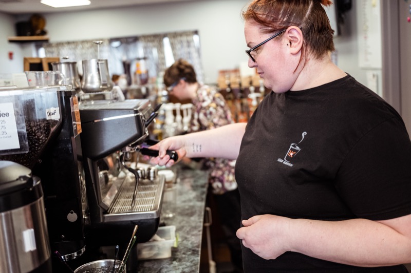 Student barista pulling espresso for a customer at the campus coffee bar