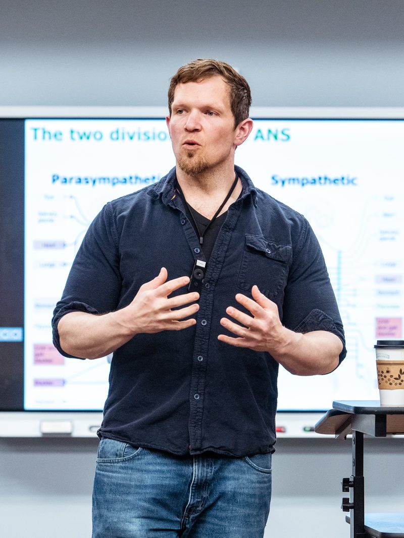 Instructor teaching a lecture in front of a classroom display