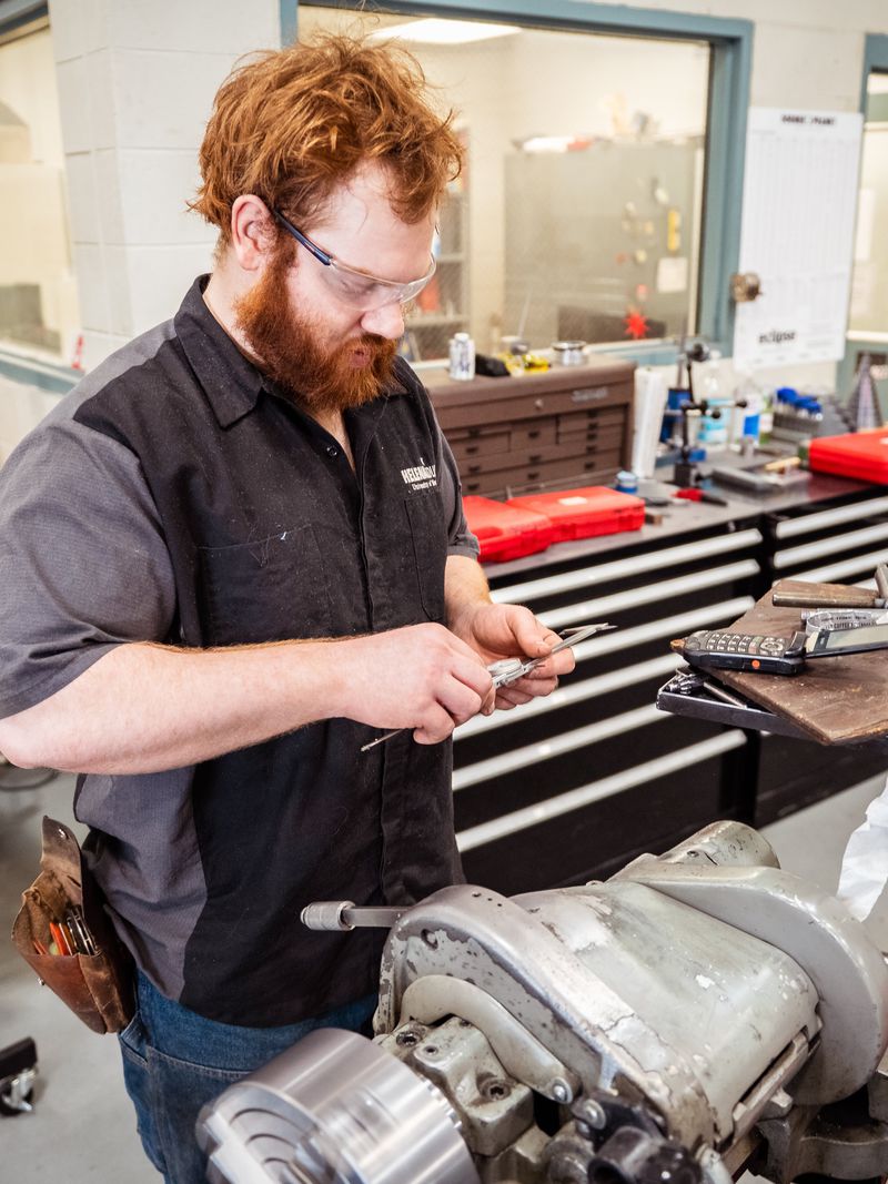 Machining instructor at a workbench in the shop